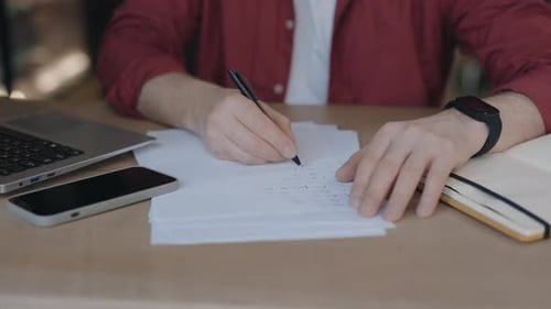 Male Freelancer Sitting at the Cafe and Taking Notes Remotely Studying