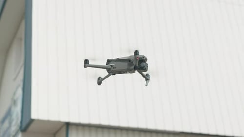 Cámara de Zumbido volando contra el fondo bokeh durante el día. Disparo de enfoque selectivo