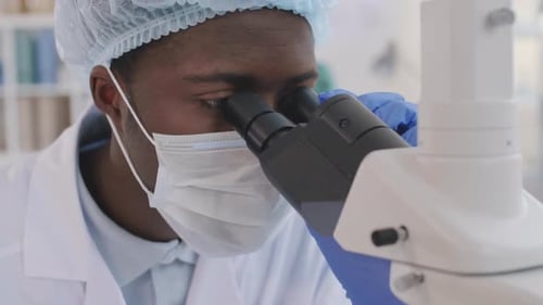 Young Adult Lab Worker Examining Microscope