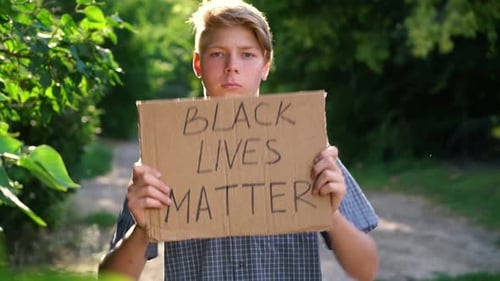 Young Adult Holding Sign in Rural Nature