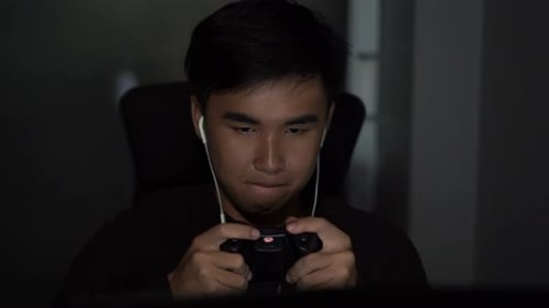 Young Man Plays Video Game at Night