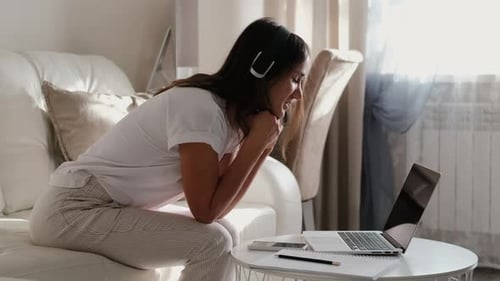 Woman Using Laptop on Couch at Home