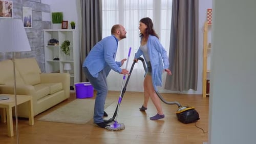 Couple Dancing While Cleaning in Their Home