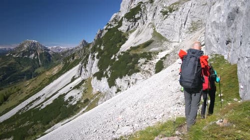 Sportliches Paar wandert in der Nähe der Felswand in den Alpen
