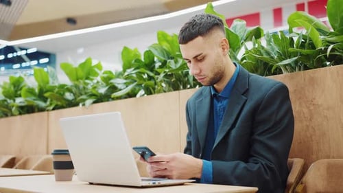Freelancer in Cafe Texting Message on Phone