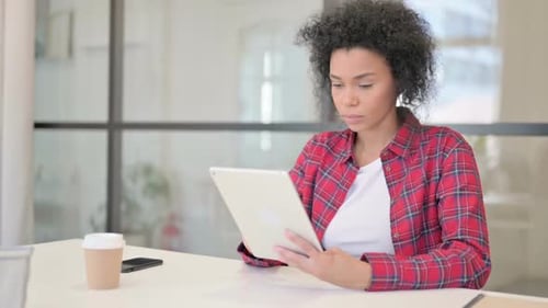 Young Adult Using Tablet at Desk