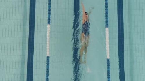Junge professionelle Schwimmerin schwimmt im Pool Frau schwimmt und trainiert im Wasserblick
