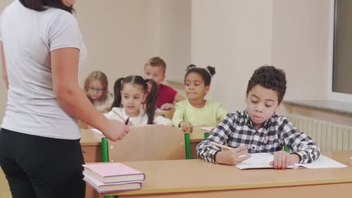 Teacher Helping Students in Elementary School Classroom