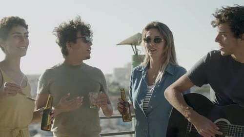 Young Adults Enjoy Drinks and Music on Rooftop