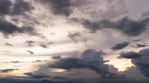 Aerial view of cloudy sky during sunset. Time lapse of the white clouds and the golden evening sky.