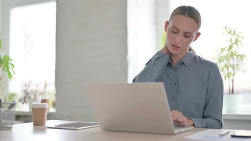 Woman Having Neck Pain While Using Laptop in Office