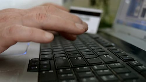 Hands Typing on Laptop, Credit Card Blurred Background