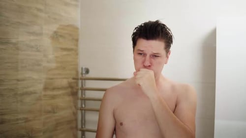 Man Examining his Teeth in Bathroom Mirror