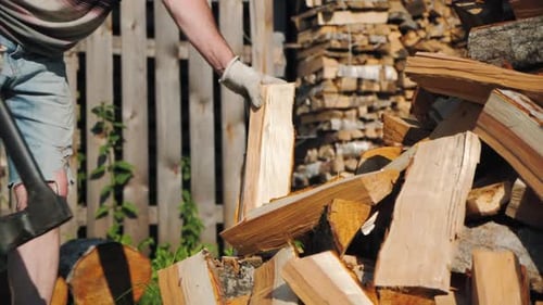 Strong Male Worker Chopping Wood Swinging and Hitting Wooden Log with Axe