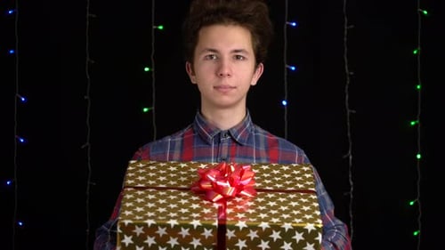 Young Adult Holding Festive Gold Gift