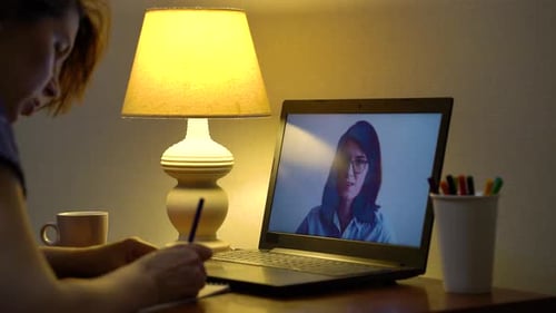 Woman Video Calling and Writing at Desk at Home