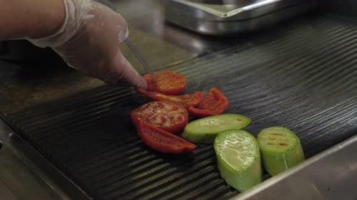 Closeup of the Restaurant's Chef Grilling Vegetables Tomato Zucchini Pepper