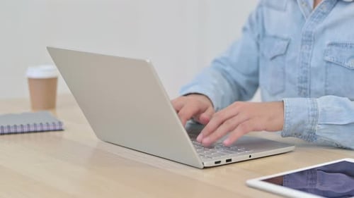 Person Opens Laptop and Types at Desk