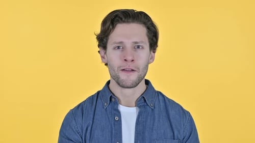Man Speaking and Gesturing on Yellow Background