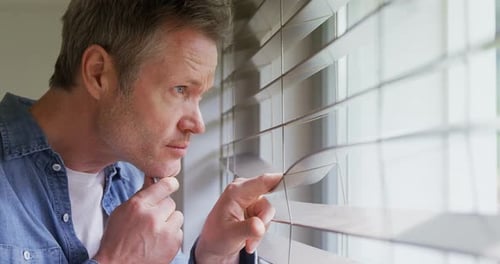 Hombre mirando hacia afuera por la ventana 4k