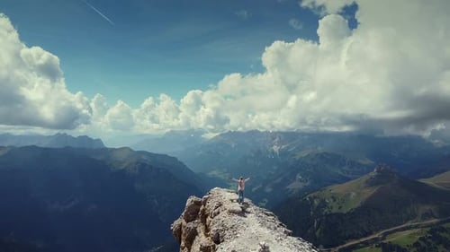 Epic Fly Over Woman with Raised Hands on the Top of Piz Boe Mountain