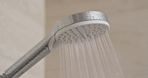Water flow from shower head in bathroom