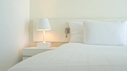 Clean Hotel Room with White Bed and Furnishings
