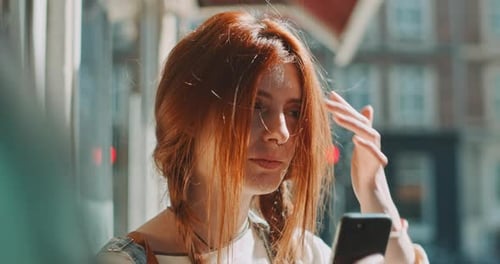 Attractive young woman using a smartphone in the city