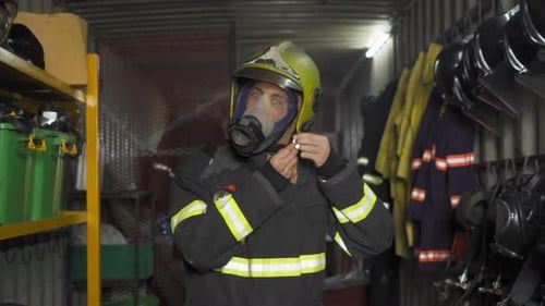 Firefighter Adjusts Gas Mask in Equipment Room
