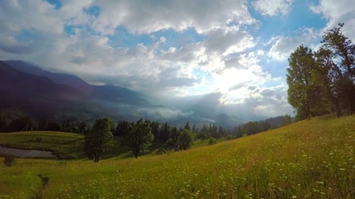 Les rayons du soleil traversent les nuages au-dessus des montagnes au coucher du soleil.