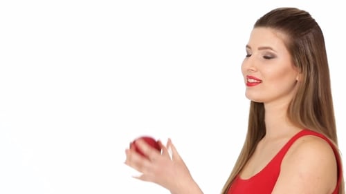 Woman in Red Tosses Apple on White Background