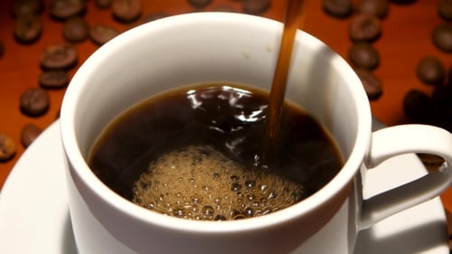 Black Coffee Poured Into a Cup Close Up