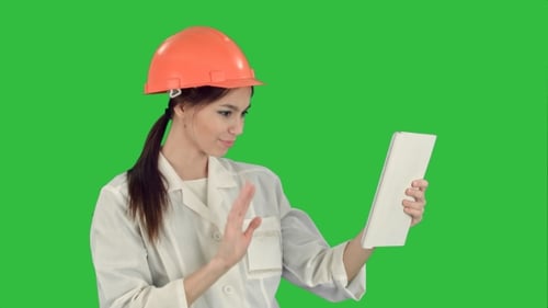 Engineer in Hard Hat Discussing Tablet Data