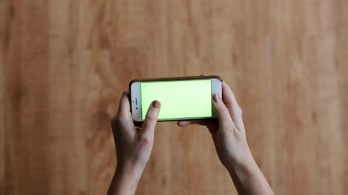 Hands with Chroma Key Green Screen on Smartphone