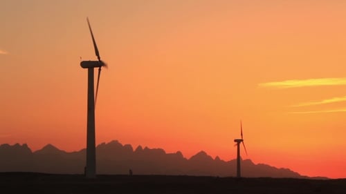 Windturbinen bei Sonnenuntergang im Hintergrund