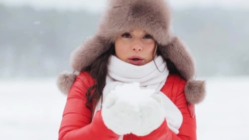 Woman Blowing Snowflakes in Snowy Weather