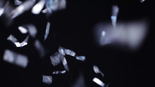 Silver Confetti Falling Over Black Background 12