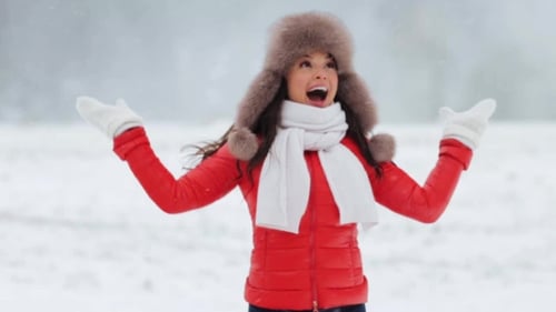 Happy Woman Enjoys Winter Snowfall Outside