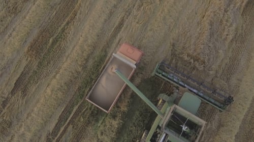 Aerial View Combine Unloads Grain in the Truck.