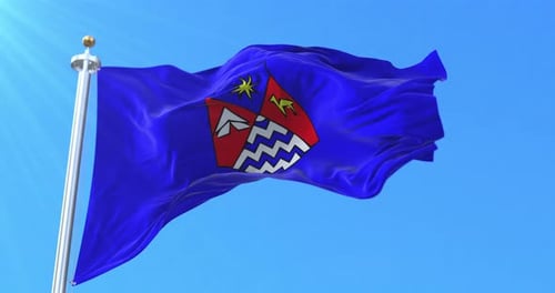 Waving Flag with Emblem Against Blue Sky