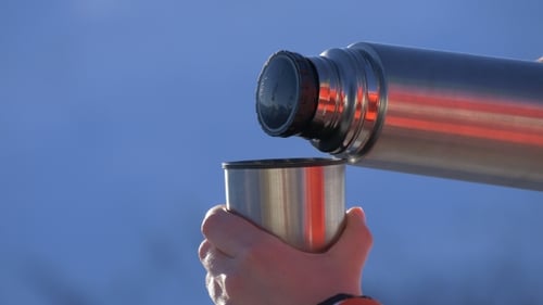 Tee aus einer Thermoskanne gießen