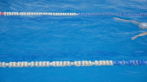 Woman Swimming Laps in an Outdoor Pool