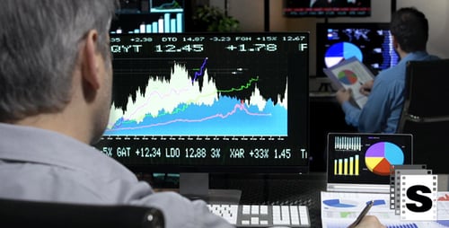 Adults Analyzing Data in Dimly Lit Office