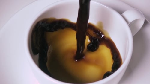Dark Coffee Being Poured into White Cup