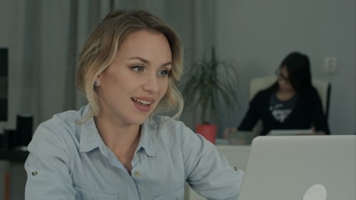 Woman Video Conferencing On Laptop in Office