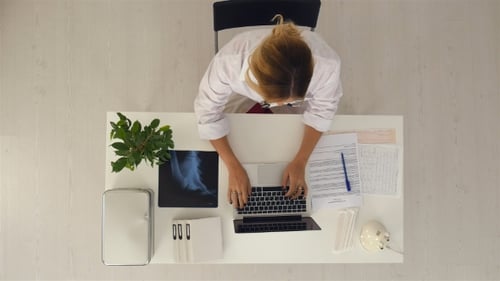 Young Pretty Female Doctor Working with Notebook in the Office.