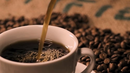 Black Coffee Being Poured Into White Coffee Mug