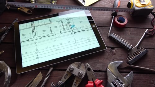 De nombreux vieux outils rouillés et une tablette moderne sur le bureau