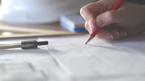 of Architect Hands with Compass Measuring Living House Blueprint