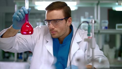 Man Examining Flask in Science Laboratory